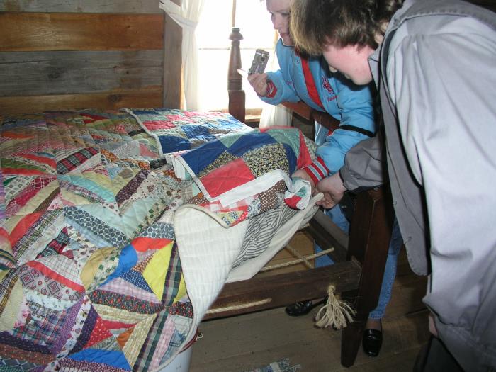 Big quilt, feather bed, and rope mattress in the bedroom